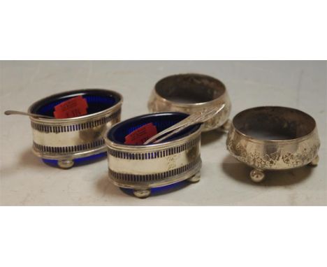 A pair of early 20th century pierced silver oval salts, each with a blue glass liner together with one other pair of early 20