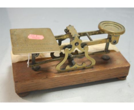 A pair of early 20th century brass postage scales and weights on oak plinth, by Sampson Morden & Co of London 