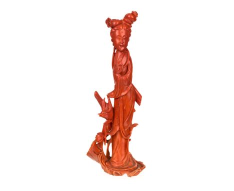 A CHINESE CARVED RED CORAL FIGURE OF A GUANYIN the goddess is shown gently touching the end of her long tresses with one hand