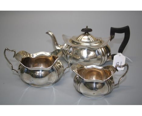 L Smith and Co, a silver three piece tea service, of serpentine panel oval form, probably Birmingham 1912 (marks rubbed), 21.