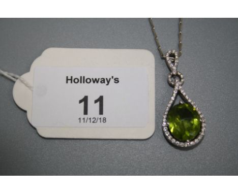 A peridot and diamond pendant, the large oval cut peridot claw mounted within a pear-shaped brilliant cut diamond surround, t