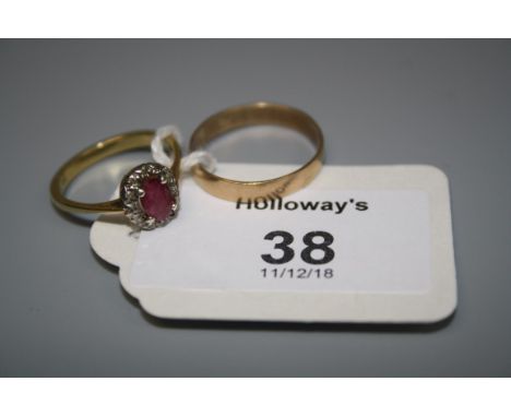 A ruby and diamond cluster ring, the oval cut ruby within a diamond set border, together with a 9ct gold wedding band