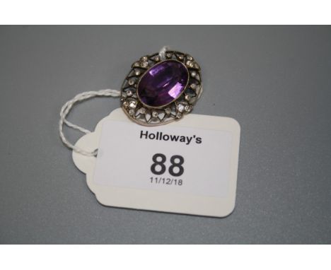A Belle Epoque amethyst and diamond open work cluster brooch, the central oval-cut amethyst within a trellis-work border of s