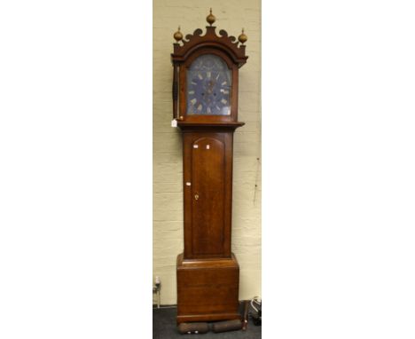 An early 19th century oak longcase clock, the arched hood with fret carved pediment and gilt ball finials enclosing blue pain