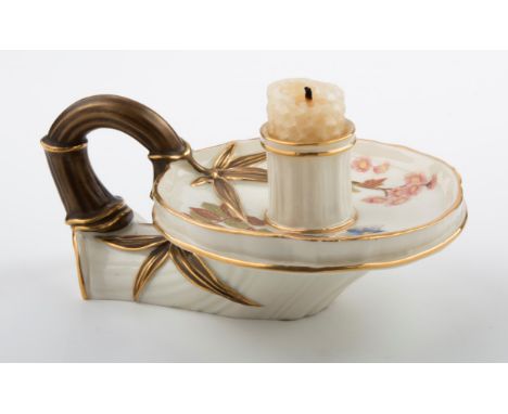 A Royal Worcester chamberstick, the florally decorated dished pan with leaf and branch handle, on an ivory and gilt ground, 1