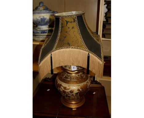 A contemporary ceramic table lamp modelled as a gilt floral relief crackle gazed spice jar and cover with a black and gold fr