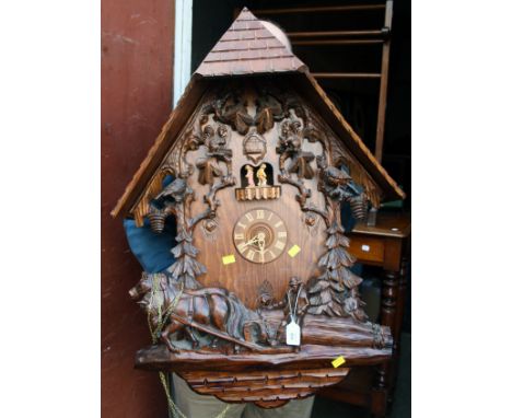 A large contemporary Black Forest cuckoo clock, the architectural case decorated with squirrels, birds and woodsman, 90 x 62c