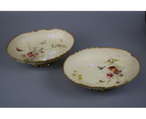 A pair or Royal Worcester oval comport dishes, design number 1427, decorated with flowers, insects and snail on a blush ivory