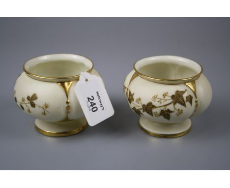 A pair of late 19th century Royal Worcester footed posy vases, decorated in shallow relief with gilded ivy and clover leaves 