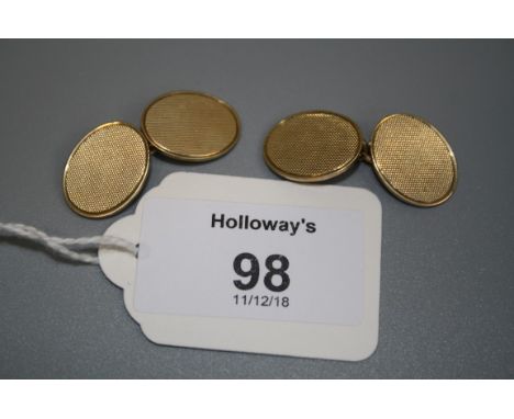 A pair of 9ct gold oval cufflinks, the engine turned plaques with chain link connections, Chester 1954