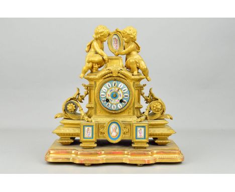 A LATE 19TH CENTURY FRENCH GILT METAL AND PORCELAIN FIGURAL MANTEL CLOCK BY JAPY FRERES, the surmount with two putti holding 