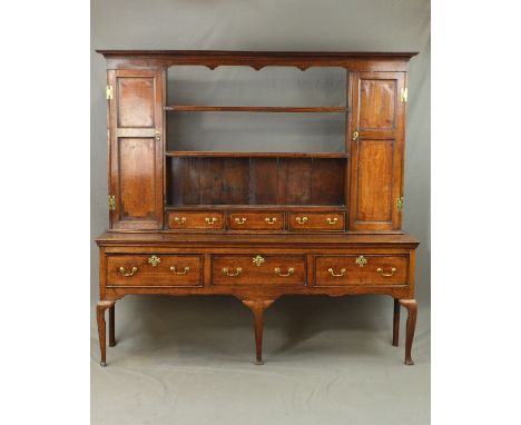 A GEORGE III OAK AND MAHOGANY BANDED DRESSER, the upper section with moulded cornice and wavy frieze above two open and one e