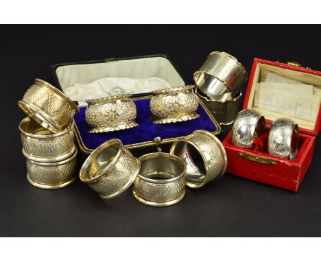 A CASED PAIR OF EDWARDIAN SILVER NAPKIN RINGS, foliate engraved decoration, maker John Rose, Birmingham 1907, together with a