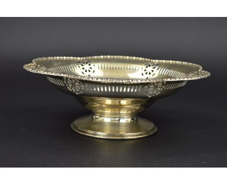 A GEORGE V SILVER PEDESTAL DISH, of wavy outline, cast bobbin reel rim, pierced border, bears presentation inscription, short