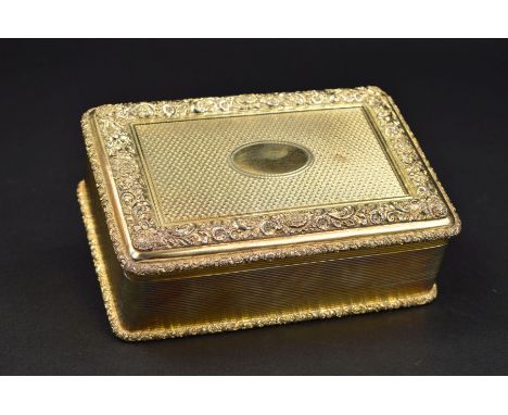 A GEORGE V SILVER GILT RECTANGULAR TABLE BOX, the hinged cover cast with foliate scroll borders enclosing engine turned decor