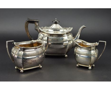 A LATE VICTORIAN SILVER THREE PIECE TEASET, of shaped oval form, gadrooned rims, banded and foliate border, milk and sugar gi