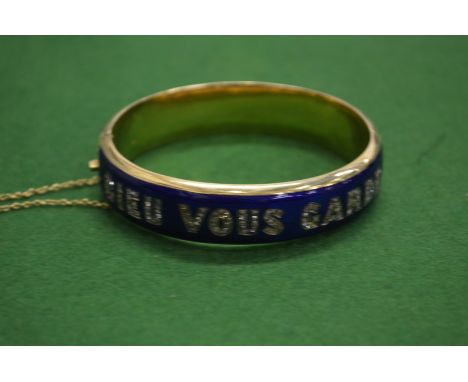 A yellow metal blue enamel and gem set hinged bangle 'Dieu Vous Garde'.