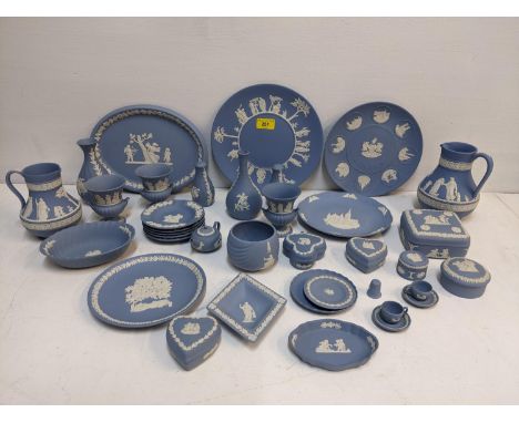 A collection of Wedgwood blue Jasperware plates, urn shaped vases, trinket boxes, miniature cups and saucers, two jugs, pin d