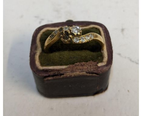 A Victorian 18ct yellow and diamond cross over ring set with two central diamonds, flanked by four smaller diamonds to each s