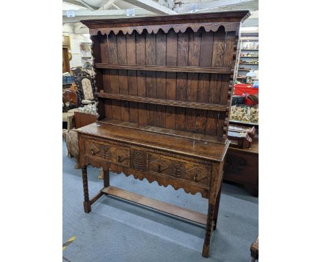 A 1920s oak dresser having a plate rack above two short drawers and on bobbin turned supports 200cm h x 136.5cm w Location: 