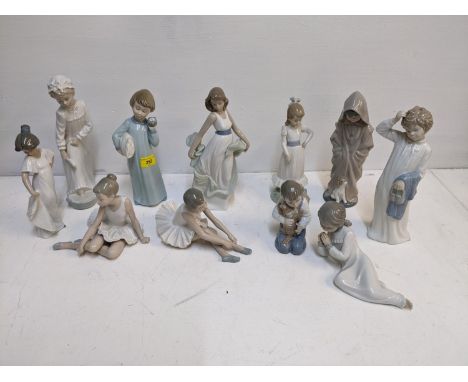 A group of eleven Nao porcelain figures to include ballerinas, a young boy kneeling with a puppy in his arms and others 