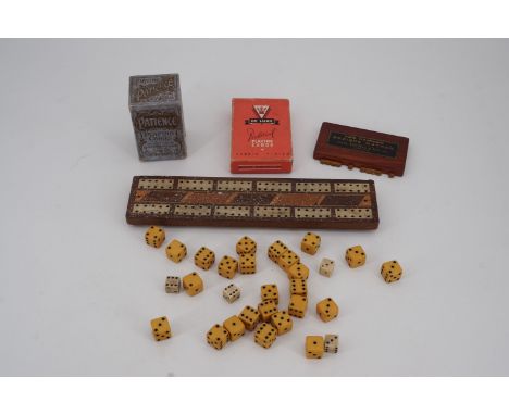 A quantity of dice, a cribbage board, Bezique Marker and two packs of playing cards