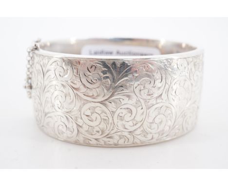 A silver hinged bangle, bearing engraved foliate scroll decoration, Birmingham, 1948