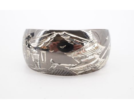 A Thai / south Asian engraved white metal bangle, circa 1960s, stomped Sterling and tested as silver