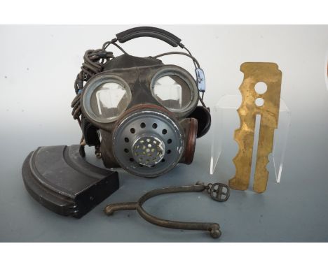 A Bren gun magazine, brass button stick, gas mask, headphones and spur