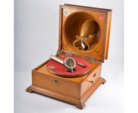 A Pathe "Elf" table gramophone, with pressed bowl speaker in lid, red flock turntable,light oak case with corner feet and ste