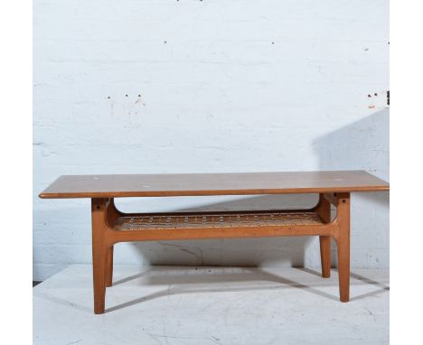 Scandinavian teak coffee table rounded rectangular top, on a shaped base with rattan magazine shelf, unlabelled, W119cm x D52