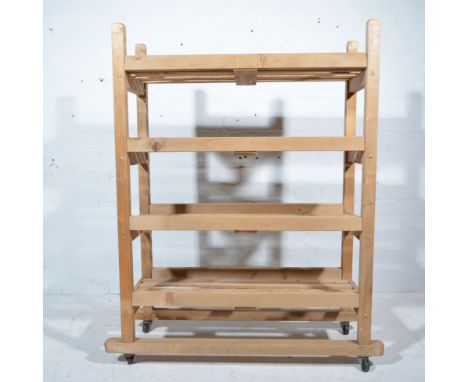 Four tier pine open shelf unit, raised on castors, W88cm x D34cm x H120cm.