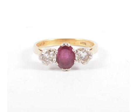 A ruby and diamond three stone ring, an oval mixed cut ruby 5.6mm x 4.7mm claw set with a brilliant cut diamond to each side 