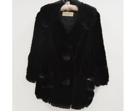 A Hardy Amies dark fur jacket, with Saville Row label, large fur covered buttons and patch pockets, a similar fur hat (no lab