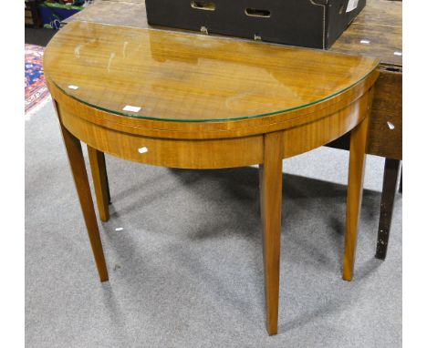 A walnut veneer demi-lune card table, supported on square tapered legs with a plate glass top, brown baize lined, width 95cm.