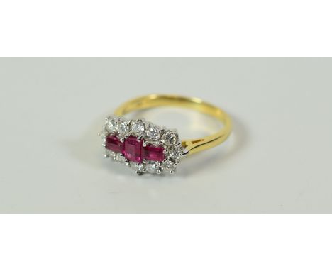 A GOOD DIAMOND & RUBY CLUSTER RING composed of three baguette rubies with twelve surrounding diamonds, 4.2gms