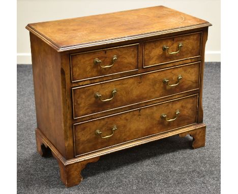 AN ANTIQUE REPRODUCTION WALNUT CHEST of two long and two short drawers in a Georgian style with bracket feet and brass swan-n