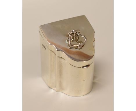 A SILVER CADDY MODELLED IN MINIATURE AS A GEORGIAN KNIFE-BOX of sloped and serpentine form with scrolling handle to the hinge