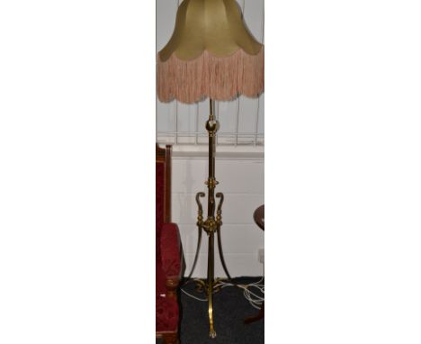 A brass pedestal lamp, shaped support, tripod legs