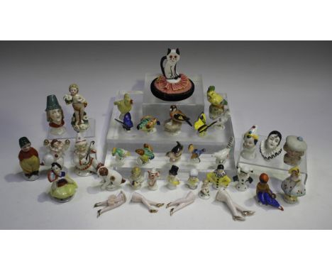A mixed group of thirty-two Continental porcelain cosy and pin cushion toppers, late 19th/early 20th century, including two h