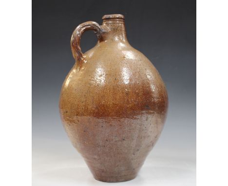 A large brown stoneware flagon, probably Rhenish, late 17th/18th century, the ovoid body with a loop handle, height 39cm.Buye