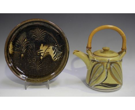 A Canadian studio pottery teapot and cover by Robin Hopper, decorated with opposing stylized foliage against a mustard glazed