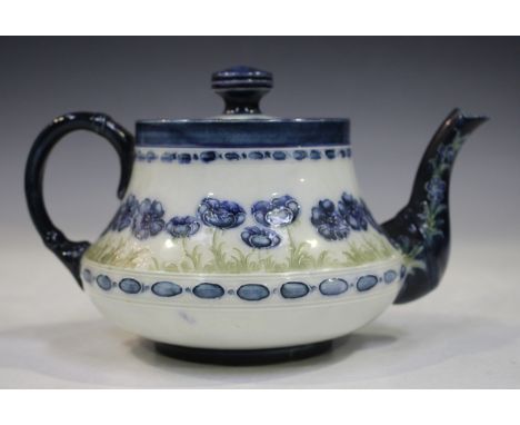 A Macintyre Moorcroft Pottery teapot and cover, early 20th century, painted with blue poppies on a white ground, brown printe