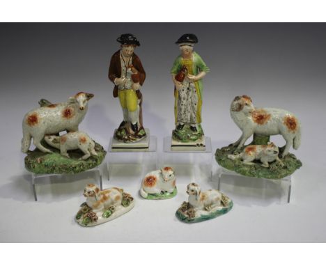 A pair of pearlware models of a ram and ewe, early 19th century, the ewe with suckling lamb, the ram with resting lamb, on na