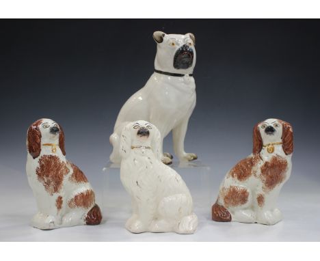 A Staffordshire pottery model of a seated pug, circa 1900, height 26.5cm, together with three Staffordshire spaniels.Buyer’s 