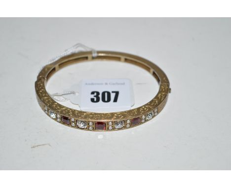 A red and white stone and seed pearl set giltmetal bangle, half engraved with leaf scrolls.
