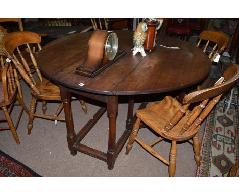 A 19th Century mahogany drop leaf dining table, with single frieze drawers above turned legs, with gate action and joined by 