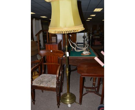 An early 20th Century extending brass standard lamp with yellow coloured tassel shade.