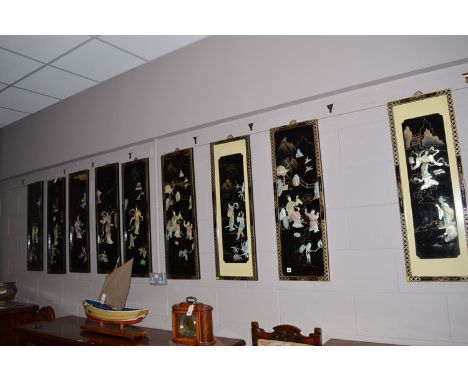 Nine Japanese lacquered wall plaques, with stained mother-of-pearl effect inlay depicting figures in landscape scenes, each 9
