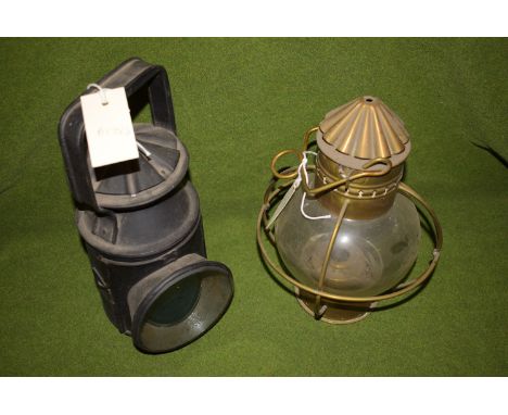 A black painted railway lamp: together with a brass oil lamp with clear glass shade.